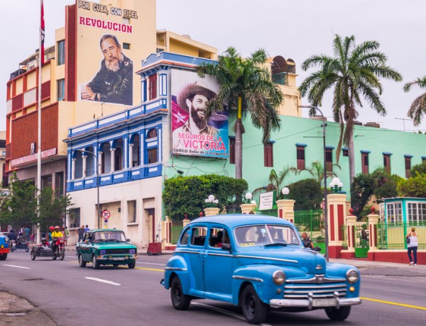 Street with oldtimers and propaganda in Santiago de Cuba